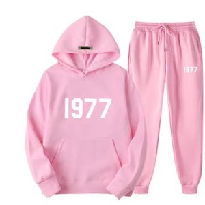 Shop the Oversized 1977 Essentials Tracksuit in Pink With White Logo. Enjoy comfort and style with this trendy, relaxed-fit tracksuit.