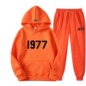 Shop the Oversized 1977 Essentials Tracksuit in Orange With Black Logo. Enjoy comfort and style with this trendy, relaxed-fit tracksuit.