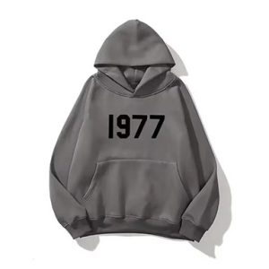 Shop the Oversized 1977 Essentials Trendy Black Grey Hoodie. Soft fleece, adjustable hood, and a relaxed fit for ultimate comfort and style.