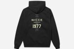 The 1977 NICCE Men's Dyna Hoodie in black features a sleek, modern design with a comfortable fit, ribbed cuffs, and a stylish logo detail.