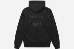 The 1977 NICCE Men's Est.13 Zip Hoodie in black features a sleek design, front zip closure, and bold branding, offering comfort and modern style.