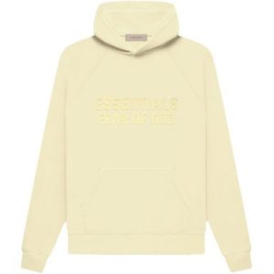 The Essentials Hoodie in Canary offers vibrant color, a relaxed fit, adjustable hood, and a kangaroo pocket, combining comfort and style effortlessly.